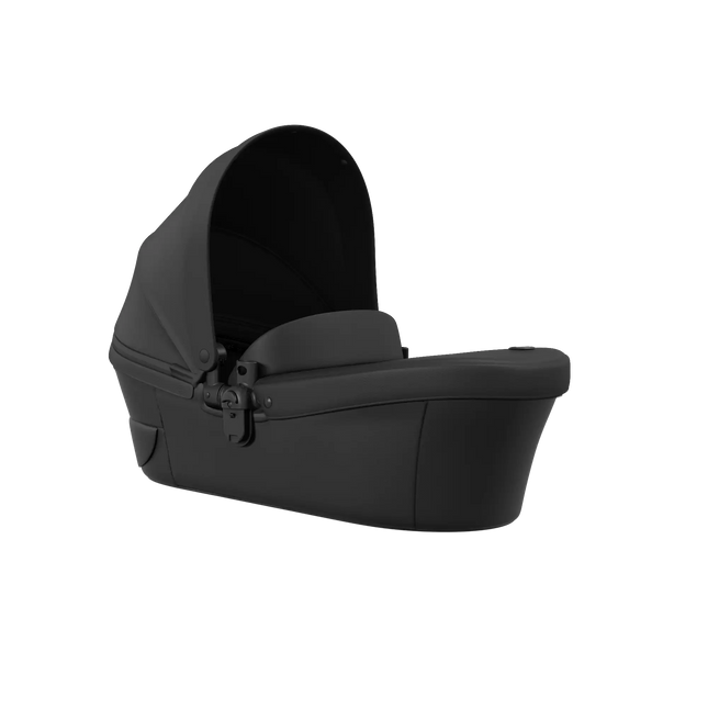 mima xari max carrycot in black with the canopy raised, shown at a three quarter angle