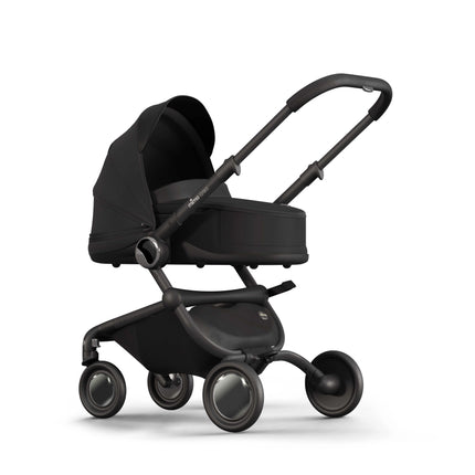 mima creo Black bassinet on the stroller chassis seen at an angle with the canopy raised
