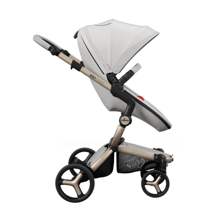 mima xari max White stroller side on, Champagne chassis with the Ruby Red seat pad just visible