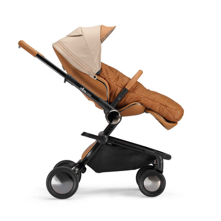 Mocha Cream footmuff zipped into the reclined mima creo seat, side view with the hood up