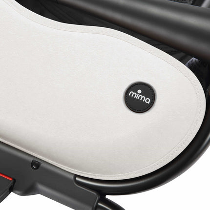 Round logo badge stitched on the cream storage basket cover of the mima creo White stroller
