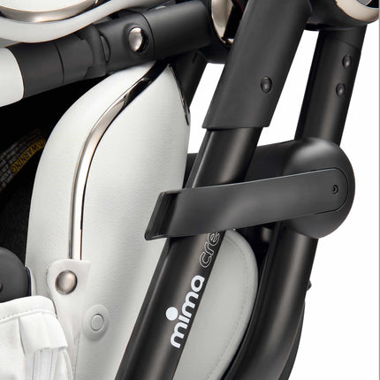 Close-up of the fold release lever and mima creo branding on the White city stroller frame