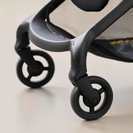 Close-up of the swiveling front wheels and footrest on the mima miro travel stroller