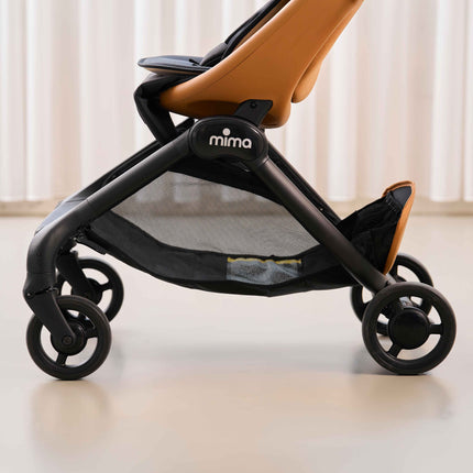 Side view of the mesh under seat storage basket on the mima miro Mocha travel stroller