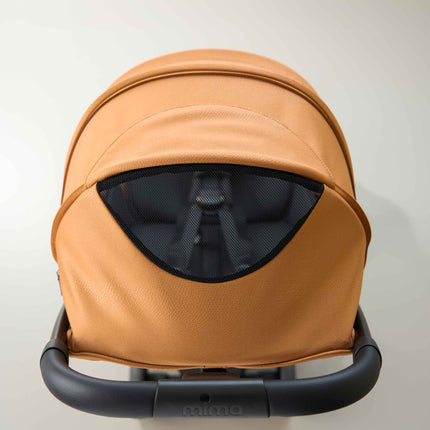 Overhead look at the extended canopy and its mesh peekaboo window on the mima miro Mocha travel stroller