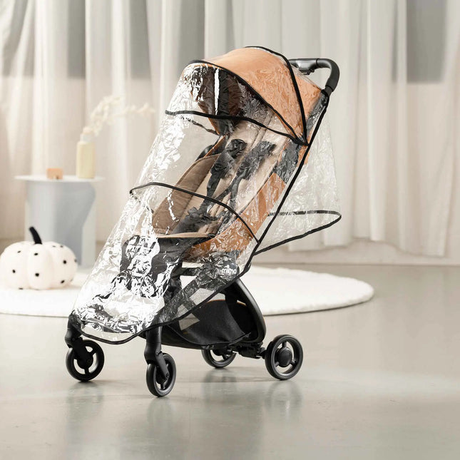 mima miro Mocha stroller wearing its clear rain cover on a polished floor in a styled living space