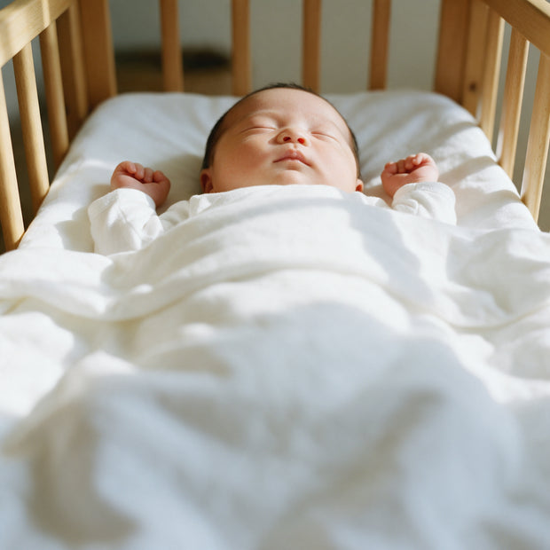 A newborn sleeps on their back in a wooden crib