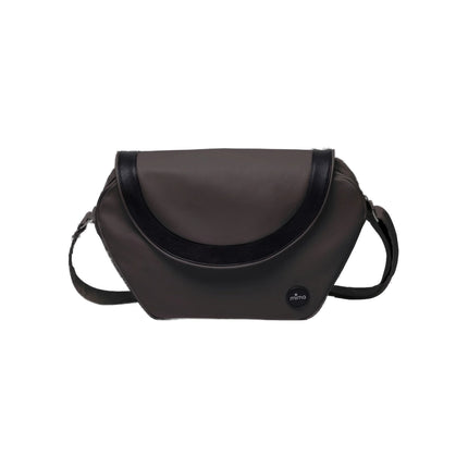 mima Trendy Changing Bag in Chocolate Brown with black flap trim, shown front on with the strap laid flat