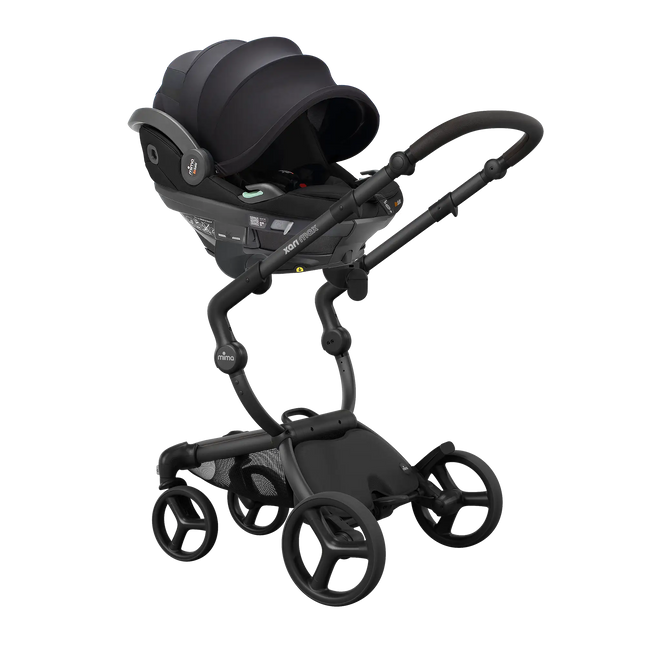 Infant car seat clicked onto the mima xari max black chassis with the adapter set, angled view